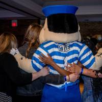 Louie hugs a group of grads at Toast